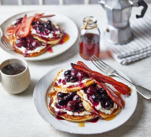 American-style pancakes topped with berries, syrup and bacon