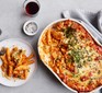 Chicken, tomato pasta bake in a dish topped with cheese