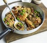 A pan filled with chicken, mushrooms, peas and bacon