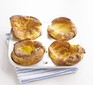 Four gluten-free Yorkshire puddings in a baking tray