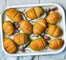 Hasselback potatoes in a baking dish with rosemary