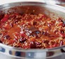 Chilli con carne cooking in a pan with chocolate melting on top