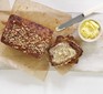 Healthy banana bread sliced with butter on a wooden board