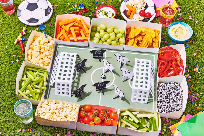 Snack stadium with boxes of snacks served around a cardboard football pitch