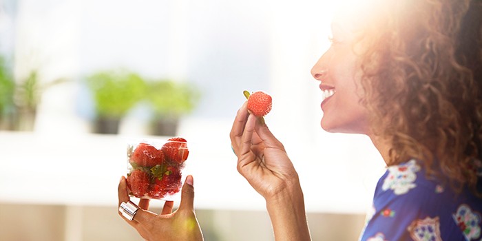 Woman eating strawberries at home