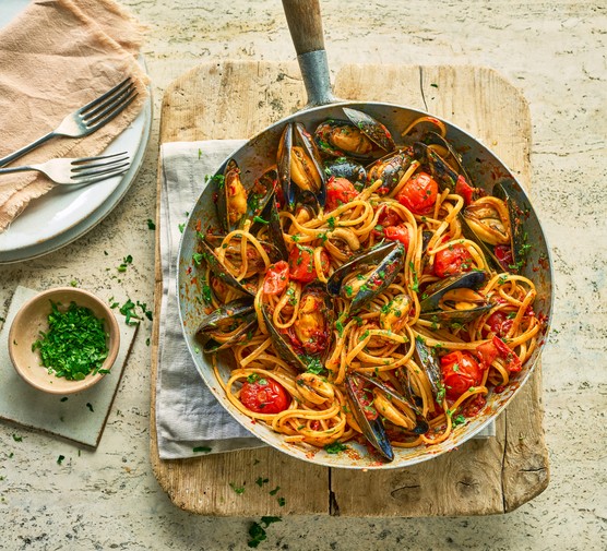 A pan of pasta with tomatoes and mussels