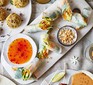 Vegan spring rolls on a serving platter with a chilli dipping sauce