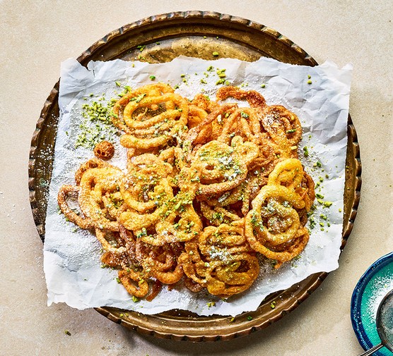 Zoolbia (lacy saffron fritters) served on a golden decorative plate